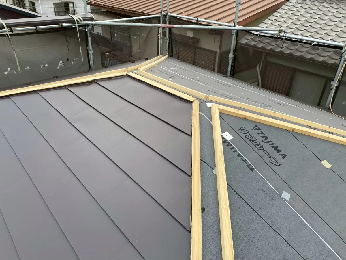既存のスレートの上に防水シートを敷き、金属の屋根材を張っている屋根カバー工法の施工中の屋根