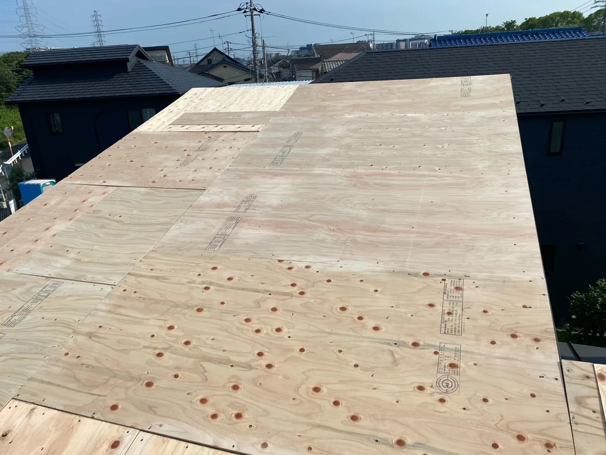 既存のスレート屋根の上に下地板を全面に張り、段差をなくした施工中の屋根