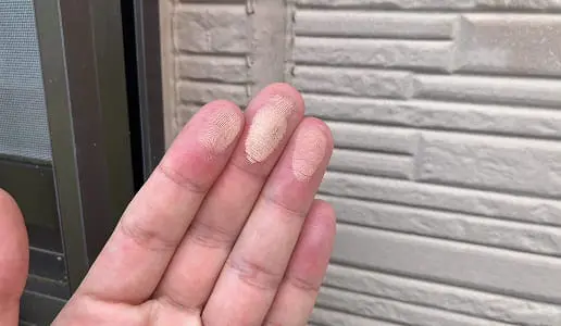 指先に付着した粉状の塗膜（チョーキング現象）を示す写真