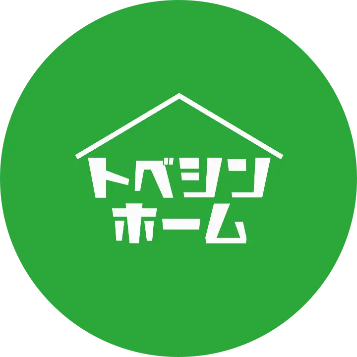 緑色の円形背景に白抜きで「トベシンホーム」と書かれたロゴマーク