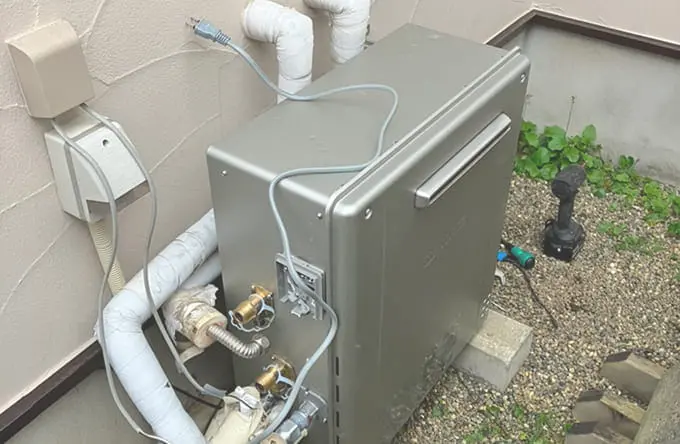 住宅の外壁に設置された給湯器本体と接続された配管の様子