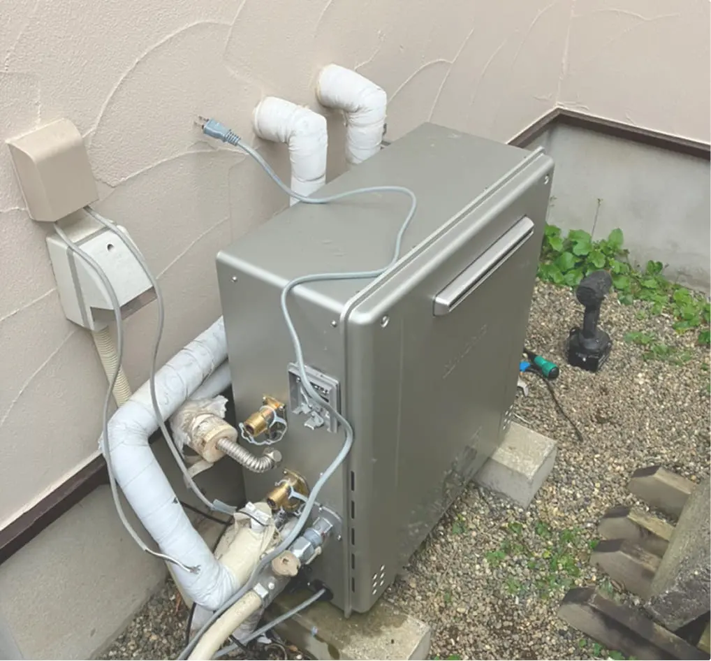住宅の外壁に設置された給湯器本体と接続された配管の様子