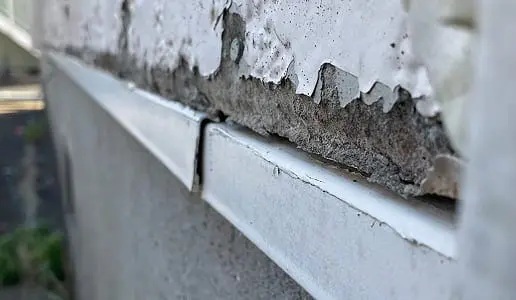 住宅の外壁を高所から撮影し、雨だれや色あせが確認できる写真