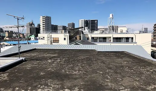 背景には高層マンションやアンテナ、水タンクなど都市の建物群が見える