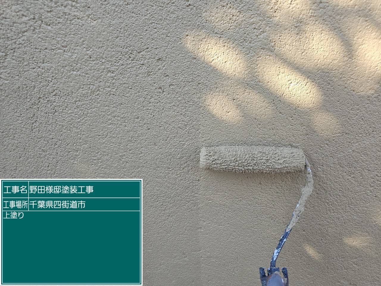 塀の上塗りをしている様子